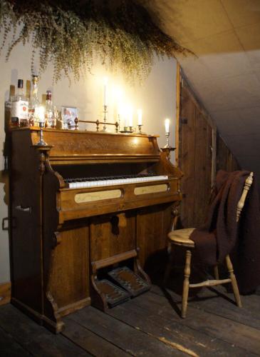 an old piano and a chair in a room at Vita Krala in Haddebo