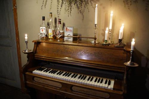 a piano with candles andcandles on top of it at Vita Krala in Haddebo