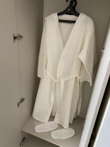 a white robe hanging on a rack in a closet at Hotel Astam in Kostanay