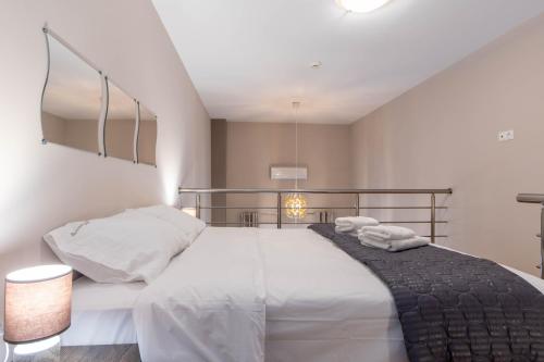a bedroom with a large white bed with towels on it at Amaryllis Maison Hili in Alexandroupoli