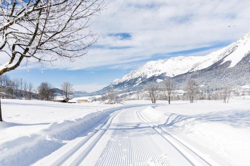 a snow covered road with mountains in the background at Haus Salina in Ellmau