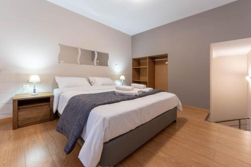 a bedroom with a large bed and a night stand at Amaryllis Maison Hili in Alexandroupoli