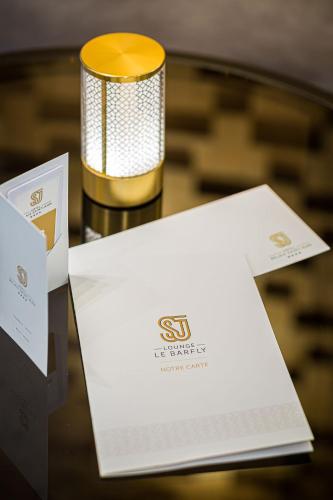 a table topped with a candle and a white envelope at Hotel Relais Saint Jean Troyes in Troyes