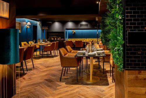 a restaurant with tables and chairs and a blue wall at Hotel Bristol Verbier in Verbier