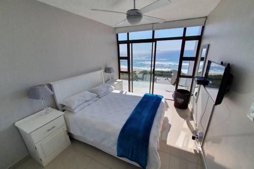 um quarto com uma cama e uma grande janela em LICORNA BEACH 51 UMHLANGA BEACHFRONT em Durban
