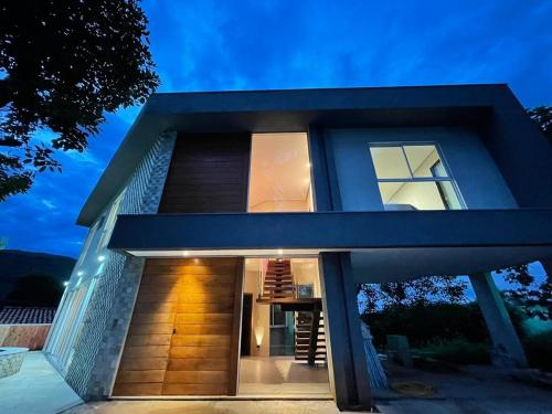 una casa con una fachada azul por la noche en Casa Escarpas do Lago, 4 suítes e ar-condicionado en Capitólio