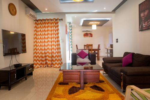 a living room with a couch and a tv at IMOLEASE Kouessi Menontin in Cotonou