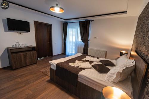 a hotel room with a bed and a television at Casa Raisa in Buşteni