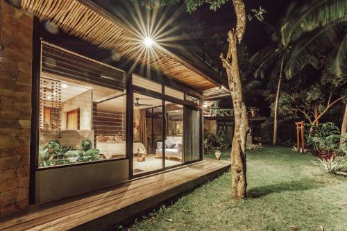a house with glass walls and a tree at Villa Kiri, Secluded Jungle Paradise in Selong Belanak