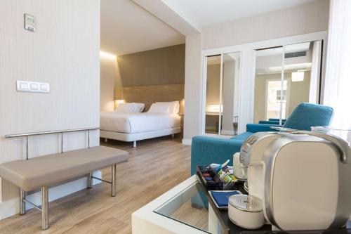 - un salon avec un canapé et un lit dans l'établissement NH Oviedo Principado, à Oviedo