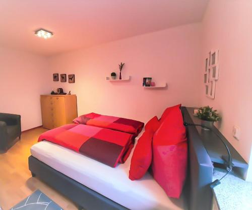 Schlafzimmer mit einem Bett mit roter und schwarzer Bettwäsche in der Unterkunft Ferienwohnung"Am Geisse Felsje" in Kirkel