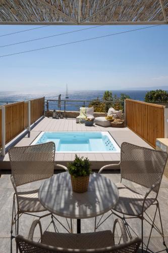 a patio with a table and chairs and a swimming pool at Atrium Hotel in Agia Paraskevi