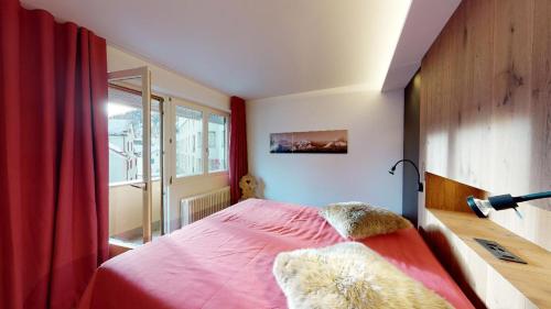 a bedroom with a pink bed and a window at Paravicini 5 in St. Moritz