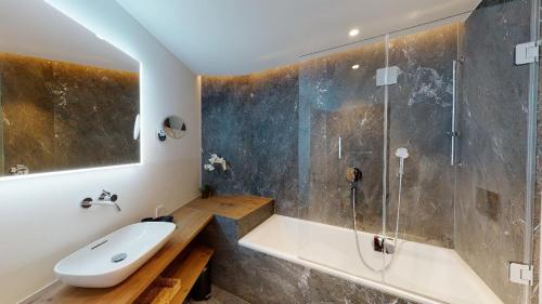 a bathroom with a tub and a sink and a shower at Paravicini 5 in St. Moritz