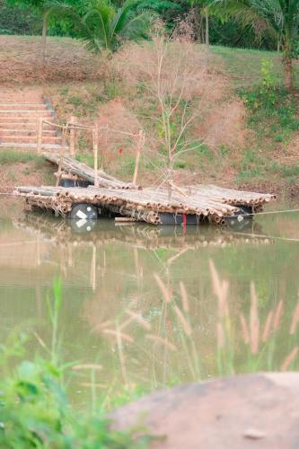 a wooden dock in the middle of a body of water at The Creek Villa in Loei