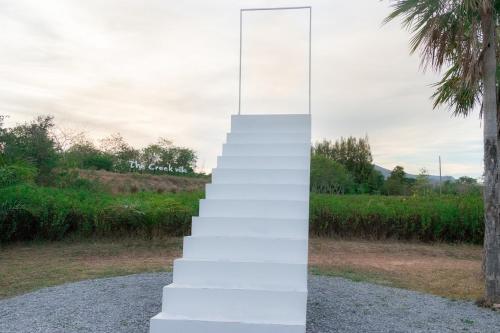 a stack of white stairs with a palm tree at The Creek Villa in Loei