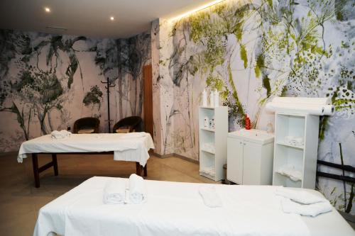 um quarto com 2 camas e um mural de parede em Flora Hotel - Apartments em Borovets