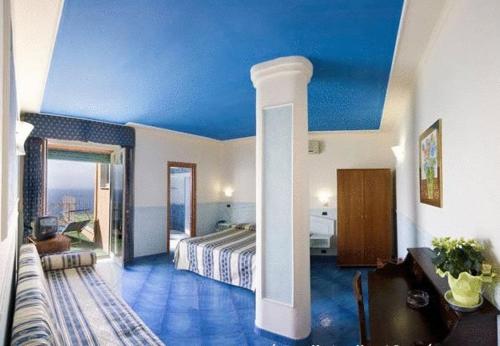 ein Hotelzimmer mit einem Bett und einer blauen Decke in der Unterkunft Hotel Klein Wien in Piano di Sorrento