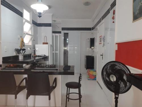 una cucina con bancone e sedie in camera di Kitnet em Guarujá - Pitangueiras (sem garagem) a Guarujá
