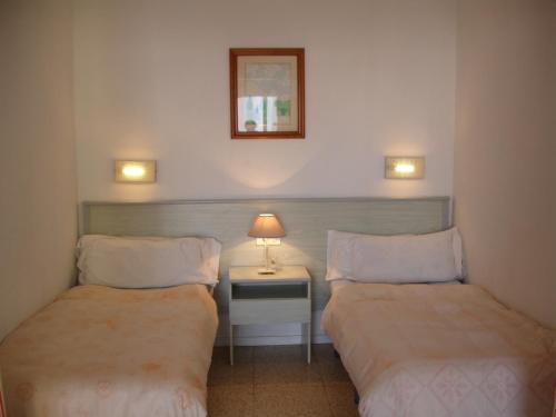 a room with two beds and a table with a lamp at Bermudas Studio - Zand Properties in Benidorm