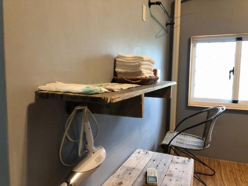 a shelf on the wall with a hair dryer and a chair at Taroko Railway Authentic B&B in Xiulin