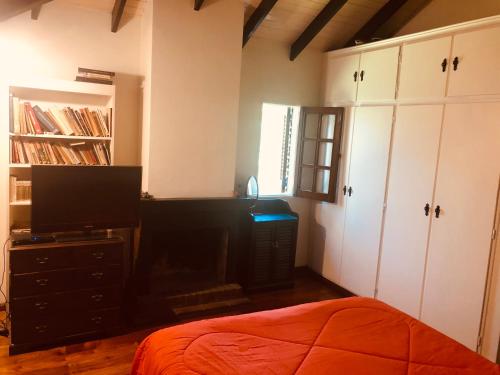 a bedroom with a bed and a tv and white cabinets at Lo del Colo in Canning