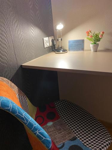 a room with a desk and a chair with a table at Hotel de Normandie in Gournay-en-Bray