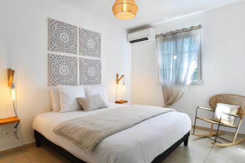 a bedroom with a large white bed and a window at Orient Bay Beach Front Apartment in Orient Bay