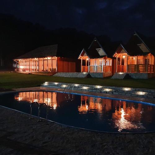 a pool in front of a building at night at Imperator Kvintil apartmani & SPA in Ležimir
