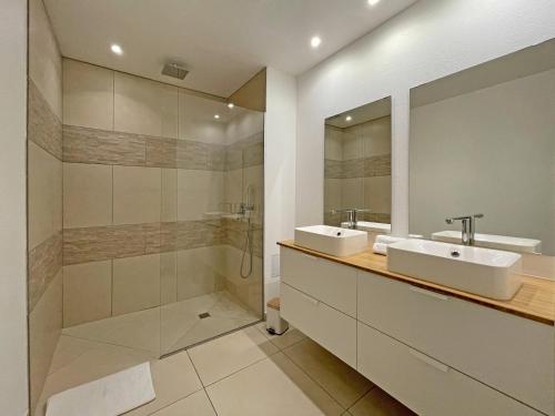 a bathroom with two sinks and a shower at Orient Bay Beach Front Apartment in Orient Bay