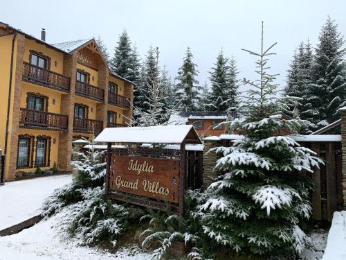 a sign in the snow in front of a resort at Idylia Grand Villas in Migovo