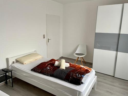 a white bedroom with a bed and a chair at Apartment für Monteure Nr 3 in Kassel