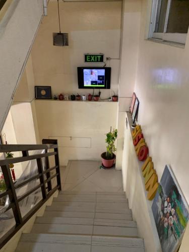 a staircase in a building with a tv on the wall at Sisko Inn in Baguio