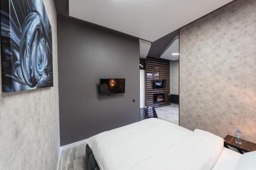a bedroom with a bed and a tv on a wall at Luxury Apartments Arena Guliver in Kyiv