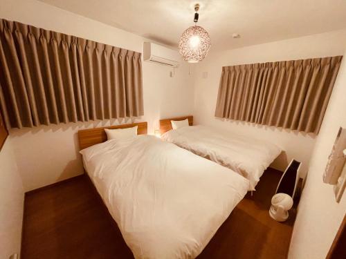 a bedroom with two beds and a chandelier at L's Mt.Fuji vacation rental in Fujikawaguchiko