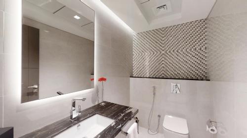 a bathroom with a sink and a toilet and a mirror at SUHA Mina Rashid Hotel Apartments in Dubai