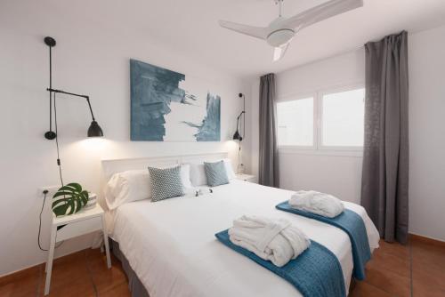 a bedroom with a white bed with towels on it at Superior G: private pool & concierge in Icod de los Vinos