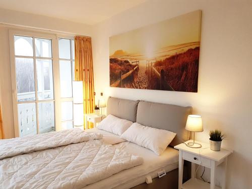 オストゼーバート・ゼリンにあるUrlaub und Erholung mit Charme und Stil auf Rügenのベッドルーム1室(ベッド1台付)が備わります。壁には絵画が飾られています。