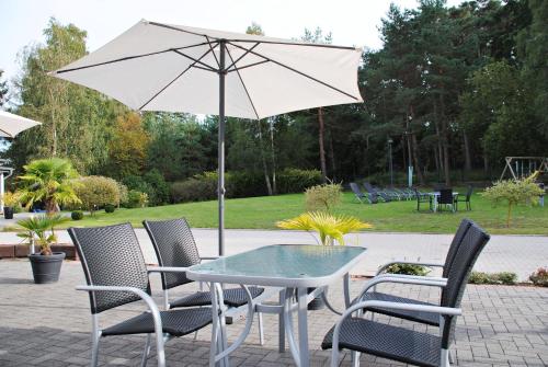 a table and chairs with an umbrella on a patio at Appartementanlage-Ferienwohnungen Weiße Möwe in Sassnitz