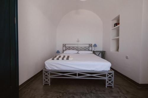 a bedroom with a white bed in a white room at Boreas Stone House in Anafi