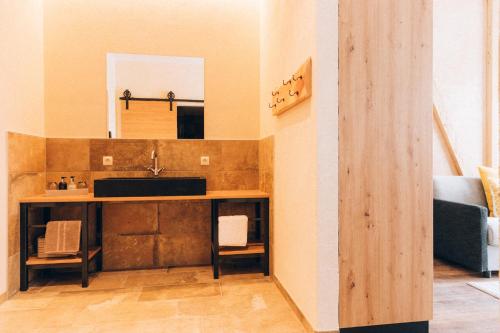 - une cuisine avec un lavabo et un miroir dans la chambre dans l'établissement Burg1990, à Ladis