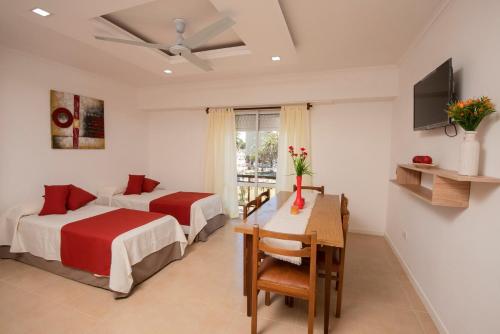 a hotel room with two beds and a table and a desk at Edificio Paseo del Sol in Necochea