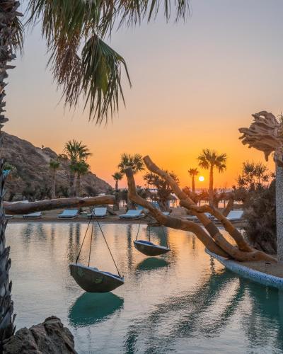 a group of boats in a body of water with palm trees at Calilo in Manganari