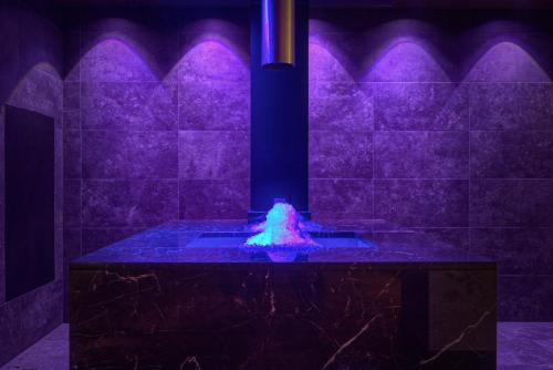 a bathroom with a blue and purple eruption in a shower at Bonfanti Design Hotel in Chienes