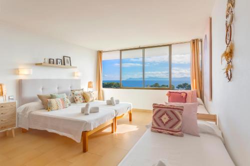 a bedroom with two beds and a large window at Apartment Alcudia Ocean View in Alcudia