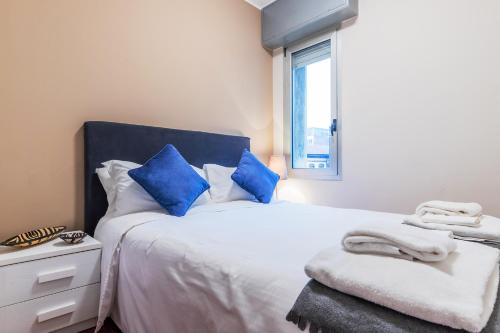 a bedroom with a bed with blue pillows and a window at Milan Retreats in Milan