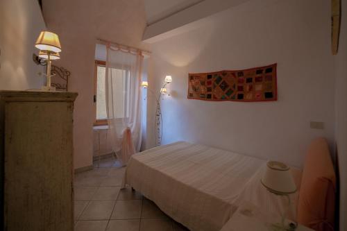 a small bedroom with a bed and a window at NICE APARTMENT in Porto Santo Stefano