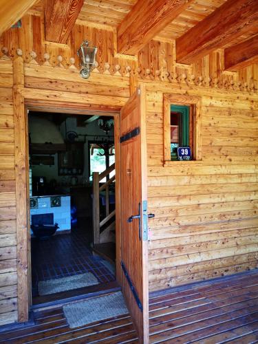 an open door of a wooden cabin at Uroczysko Leźno in Małe Leżno
