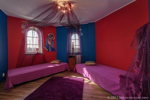 グダニスクにあるHotelik Bachの赤と青の壁のドミトリールームのベッド2台