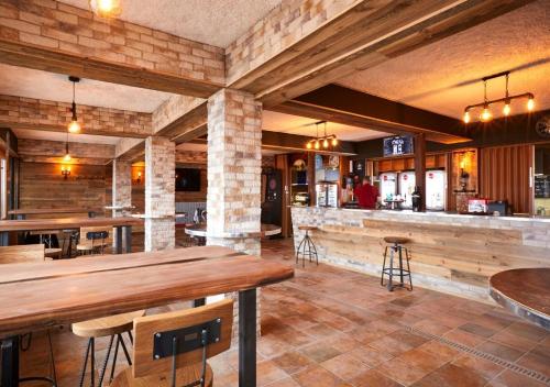 a restaurant with wooden tables and a bar at Hôtel des Portes du Soleil in Les Crosets